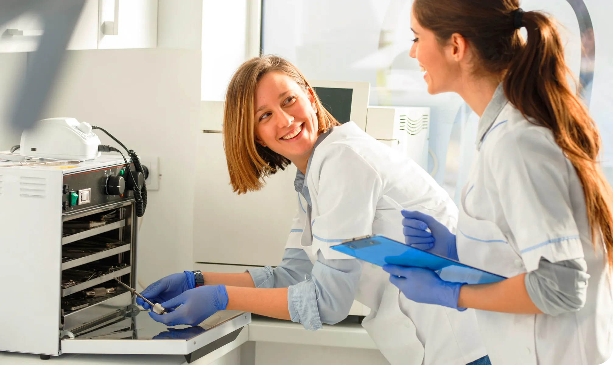 Two healthcare professionals working to sterilize medical instruments
