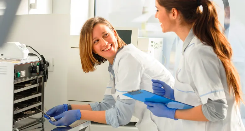 Two healthcare professionals working to sterilize medical instruments